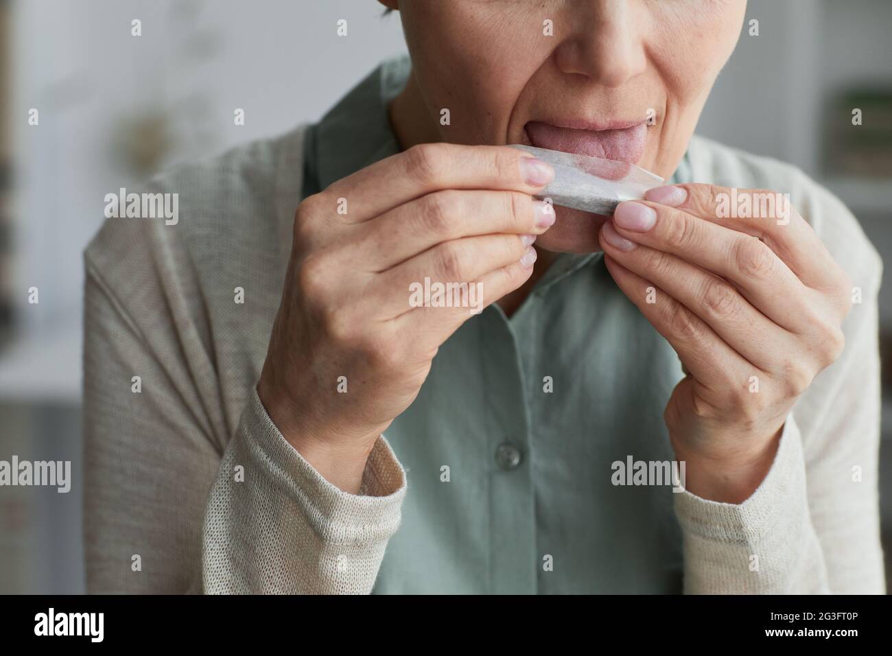 Nahaufnahme einer unkenntlich reifen Frau, die für medizinische Zwecke eine Zigarette rollt, Platz zum Kopieren Stockfoto