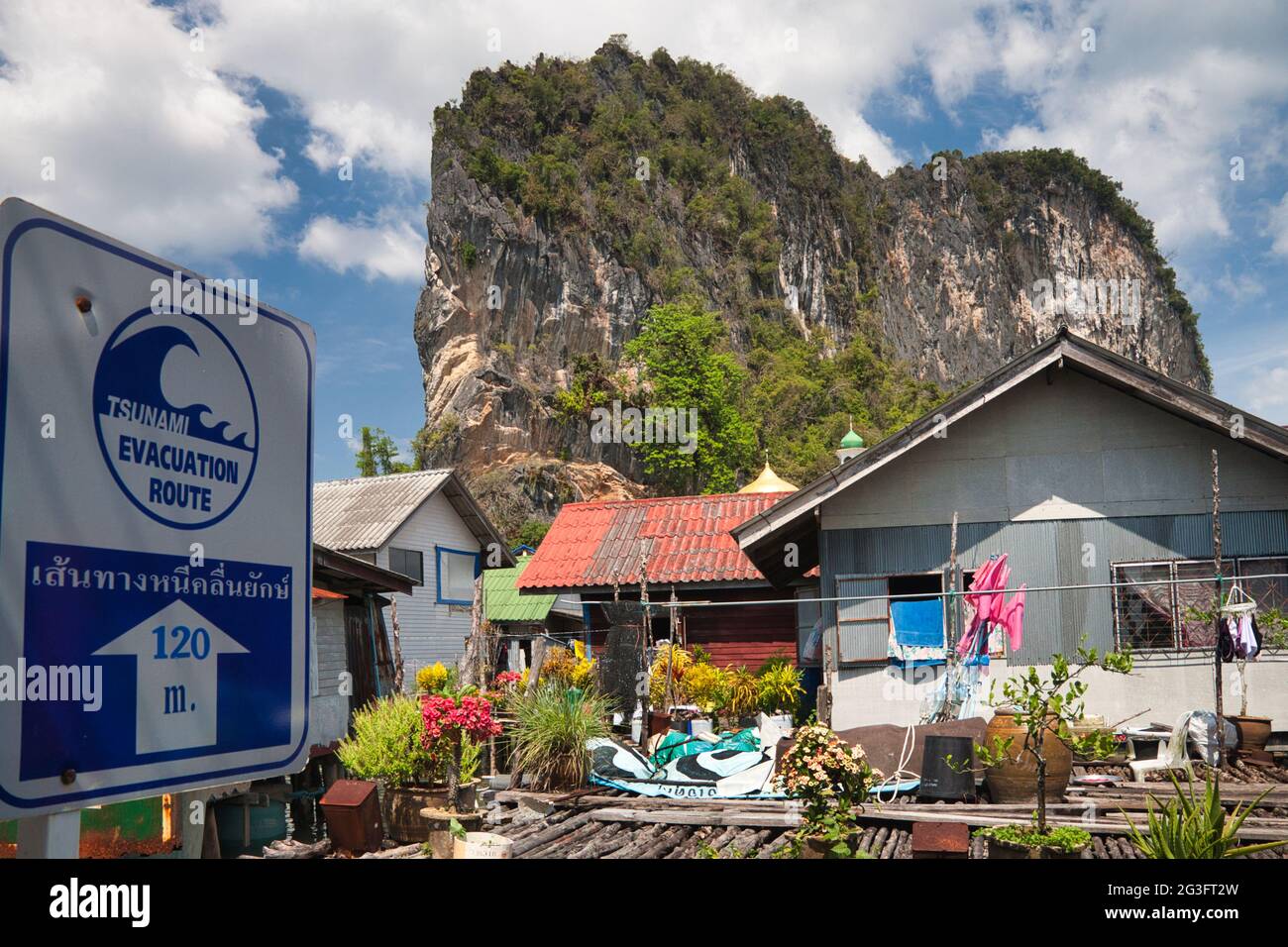 Ein Wasserdorf auf Stelzen in der Phang Nga Bay Thailand gebaut. Ein Schild, das zeigt, wo man evakuieren sollte, wenn ein Tsunami passieren würde Stockfoto