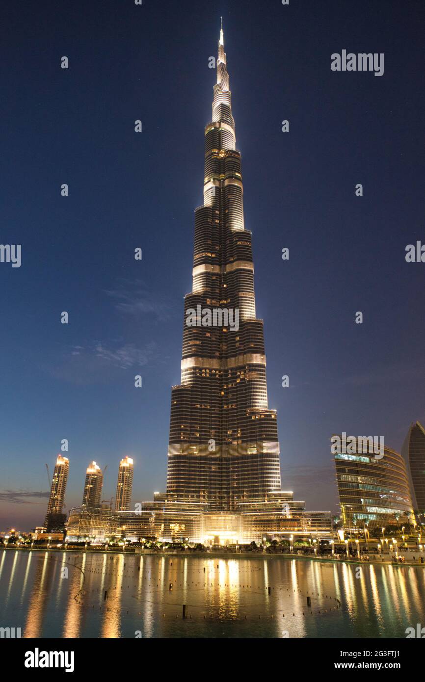 Das höchste Gebäude der Welt, der Burj Khalifa, erleuchtete in der Dämmerung mit Reflexionen im See vor Dubai, den Vereinigten Arabischen Emiraten Stockfoto