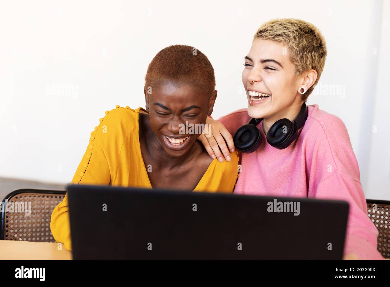 Lesbisches Paar mit Laptop auf Tisch zu Hause Stockfoto