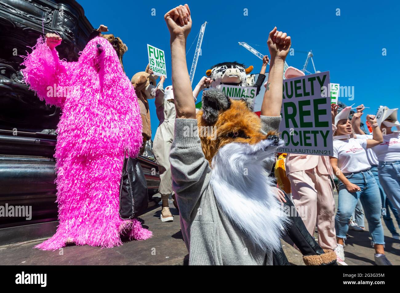 London, Großbritannien. 16. Juni 2021. Menschen in Tierkostümen bei einem Anti-Tierquälerei-Protest im Piccadilly Circus, unterstützt von der Modedesignerin Stella McCartney, ermutigten die Öffentlichkeit, die HSI fur Free Britain Petition zu unterschreiben. Die Botschaft „Unsere Zeit ist gekommen“ aus McCartneys Herbst-2021-Kampagne wird auf den großen Bildschirmen hinter ihnen angezeigt. Kredit: Stephen Chung / Alamy Live Nachrichten Stockfoto