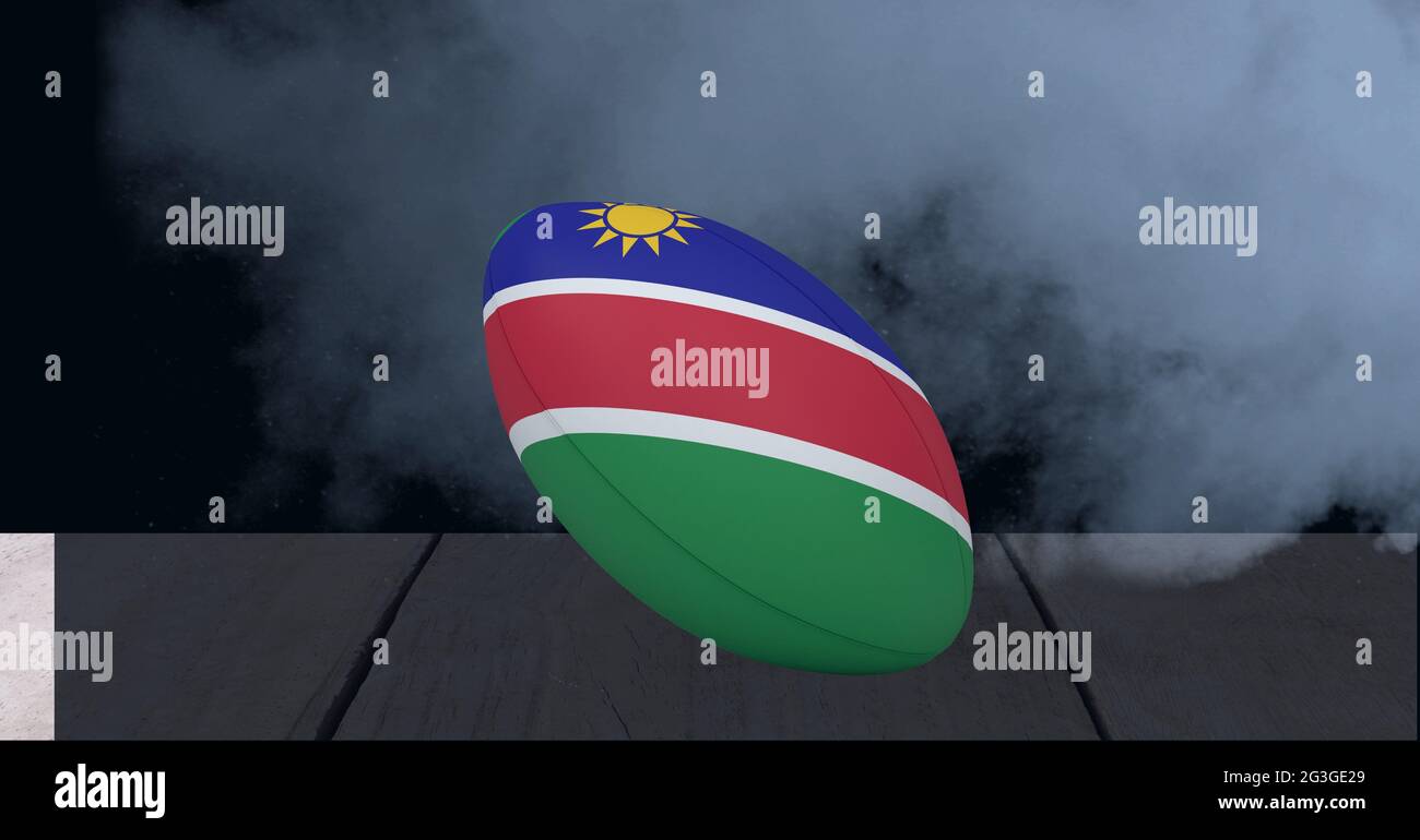 Namibia Flagge auf Rugby Ball über Holzoberfläche gegen Raucheffekt auf schwarzem Hintergrund Stockfoto