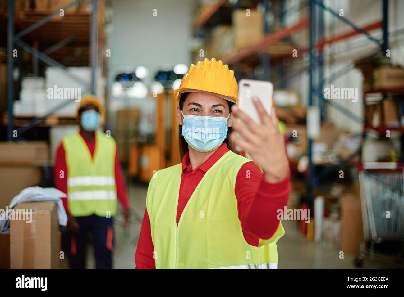 Fröhlicher Lagerarbeiter, der Selfie mit dem Smartphone gemacht hat Stockfoto