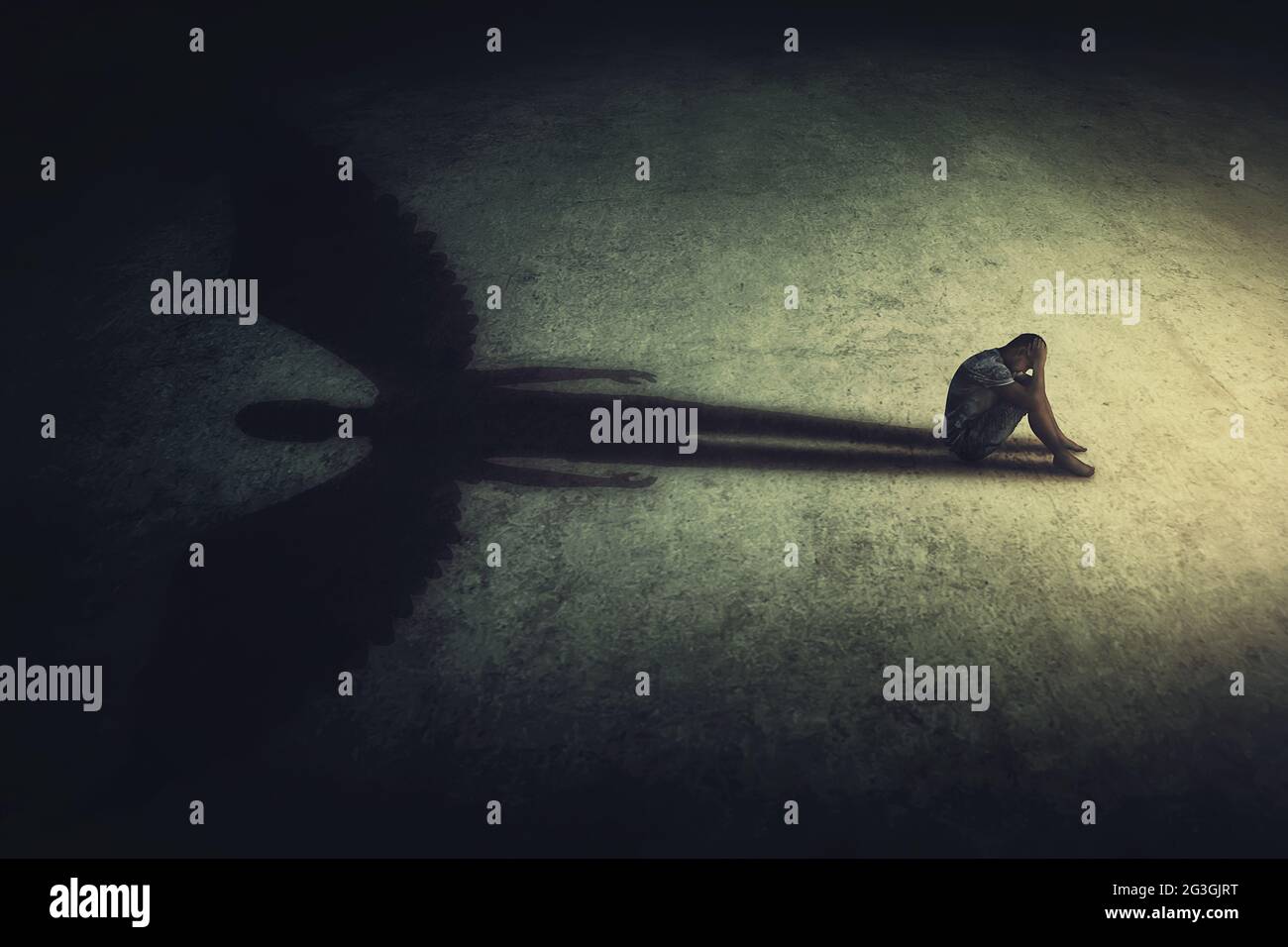 Deprimierter junger Mann, der allein in einem dunklen Raum sitzt und einen Schatten eines mächtigen Schutzengels wirft. Innere Stärke konzeptioneller Hintergrund. Stress Stockfoto