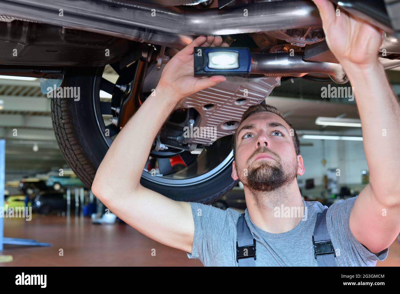 Automechaniker repariert Fahrzeug in einer Werkstatt - Bremsen auf Sicherheit prüfen Stockfoto