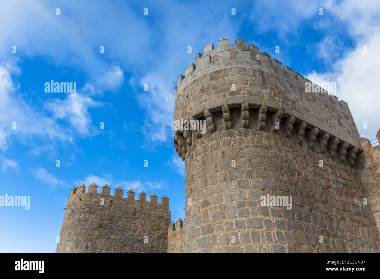 Ávila / Spanien - 05 12 2021: Detailansicht der Stadtmauer und des Festungsturms von Ávila, blauer Himmel als Hintergrund Stockfoto