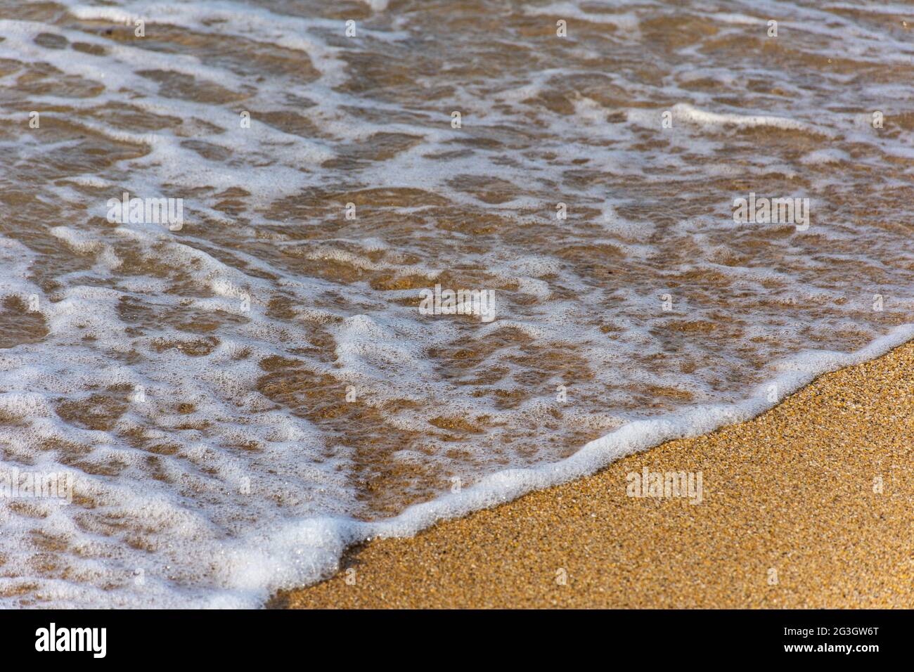 Schaumwellen am Strand, Urlaubskonzept. Stockfoto