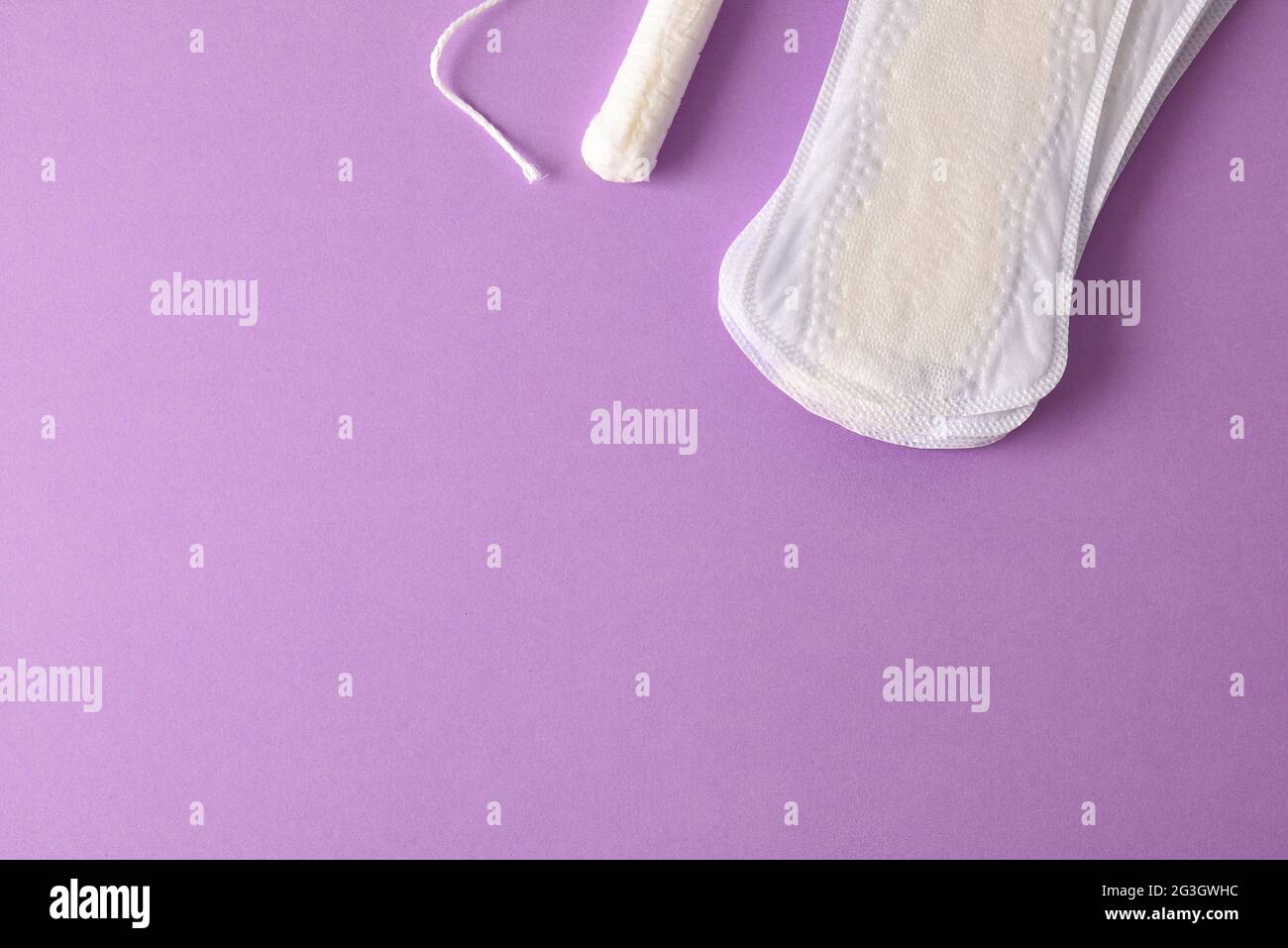 Hintergrund mit weiblichen Protektoren für den Menstruationszyklus auf lilafarbischem Hintergrund. Draufsicht. Horizontale Zusammensetzung. Stockfoto