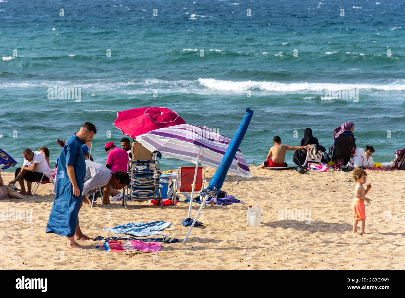 Zwei arabische Männer beten am Strand, Sommerurlaub. Stockfoto