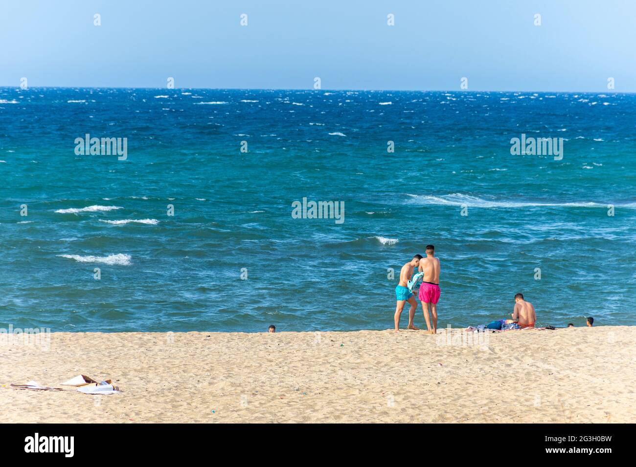 Junge algerische Menschen tragen Shorts am Strand. Stockfoto