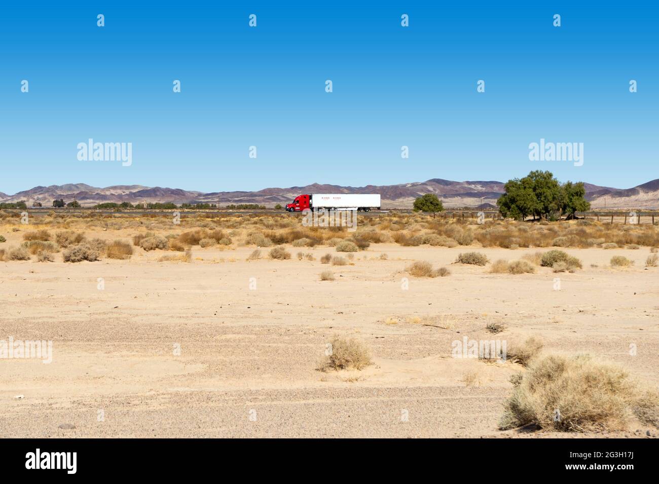 Newberry Springs, CA, USA – 18. Februar 2021: Sattelschlepper mit Anhänger auf der Interstates 40 in der Mojave-Wüste in Newberry Springs, Californi Stockfoto