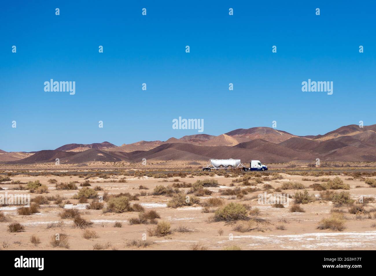 Newberry Springs, CA, USA – 18. Februar 2021: Sattelschlepper mit einem trockenen Bulk-Anhänger auf der Interstates 40 in der Mojave-Wüste bei Newberry Sprins Stockfoto