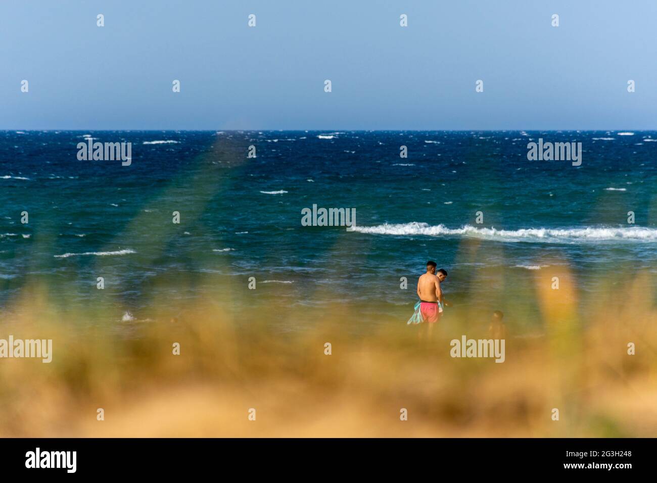 Gruppe von jungen Menschen am Strand, Freunde Abenteuer, Sommerurlaub, verschwommener Vordergrund. Stockfoto