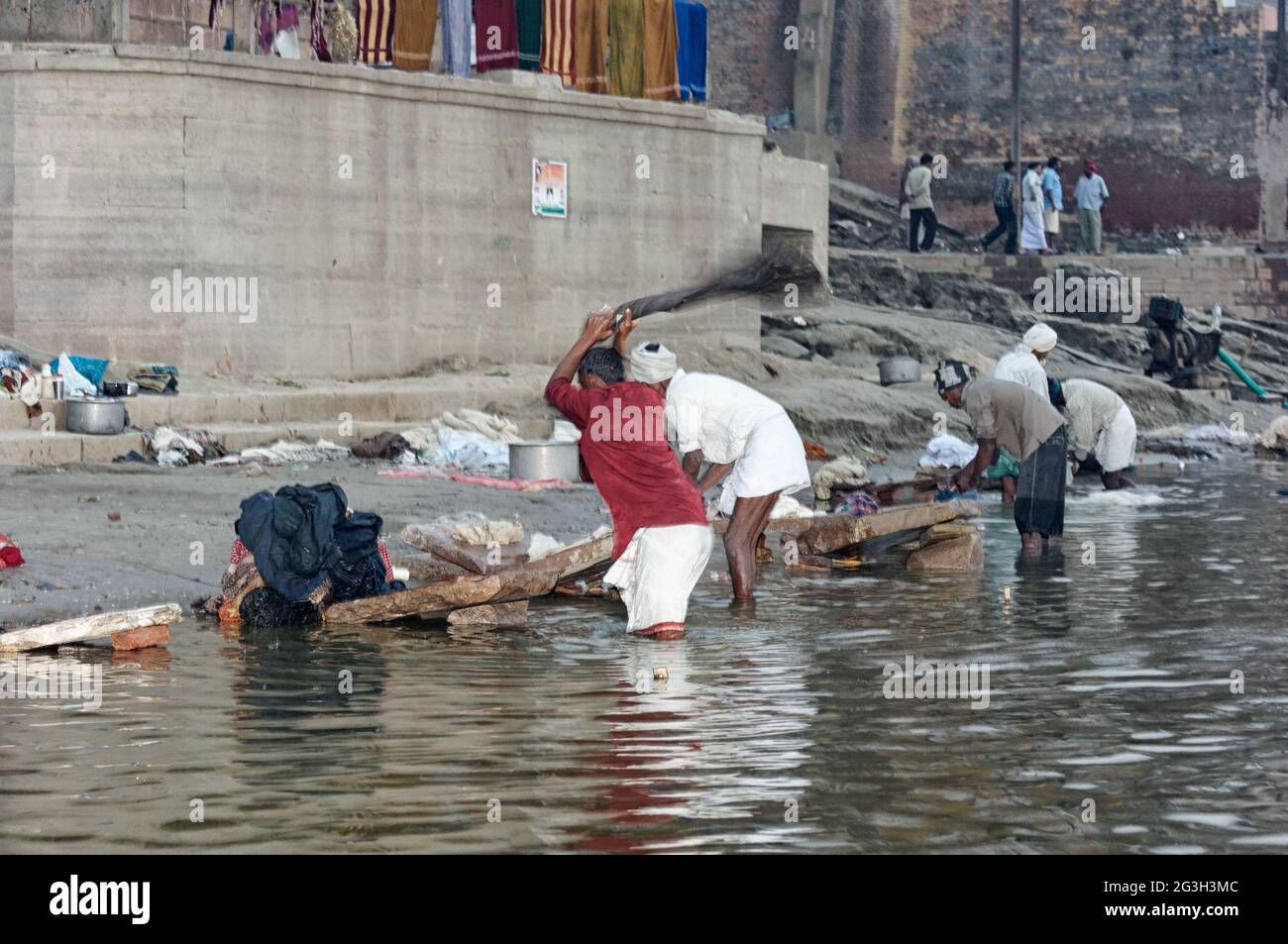 Die Wäscherinnen im Ganges reinigen ihre Kleidung in schmutzigem, aber heiligem Wasser Stockfoto