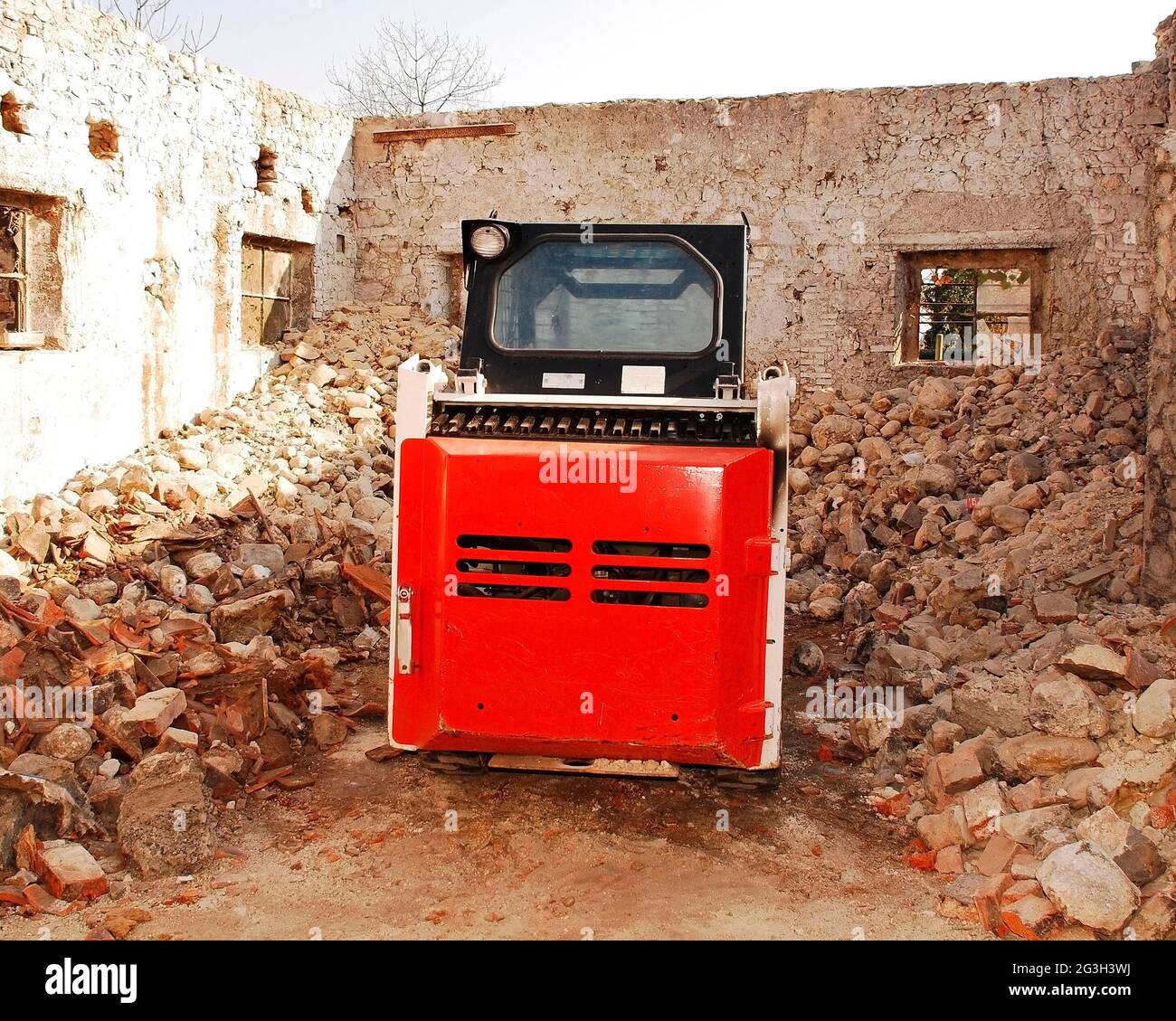 Ein Bobcat-Kompaktlader in einem teilweise abgerissenen alten italienischen Steinbauernhof in der Provinz Udine, Friaul-Julisch Venetien, Nordostitalien Stockfoto