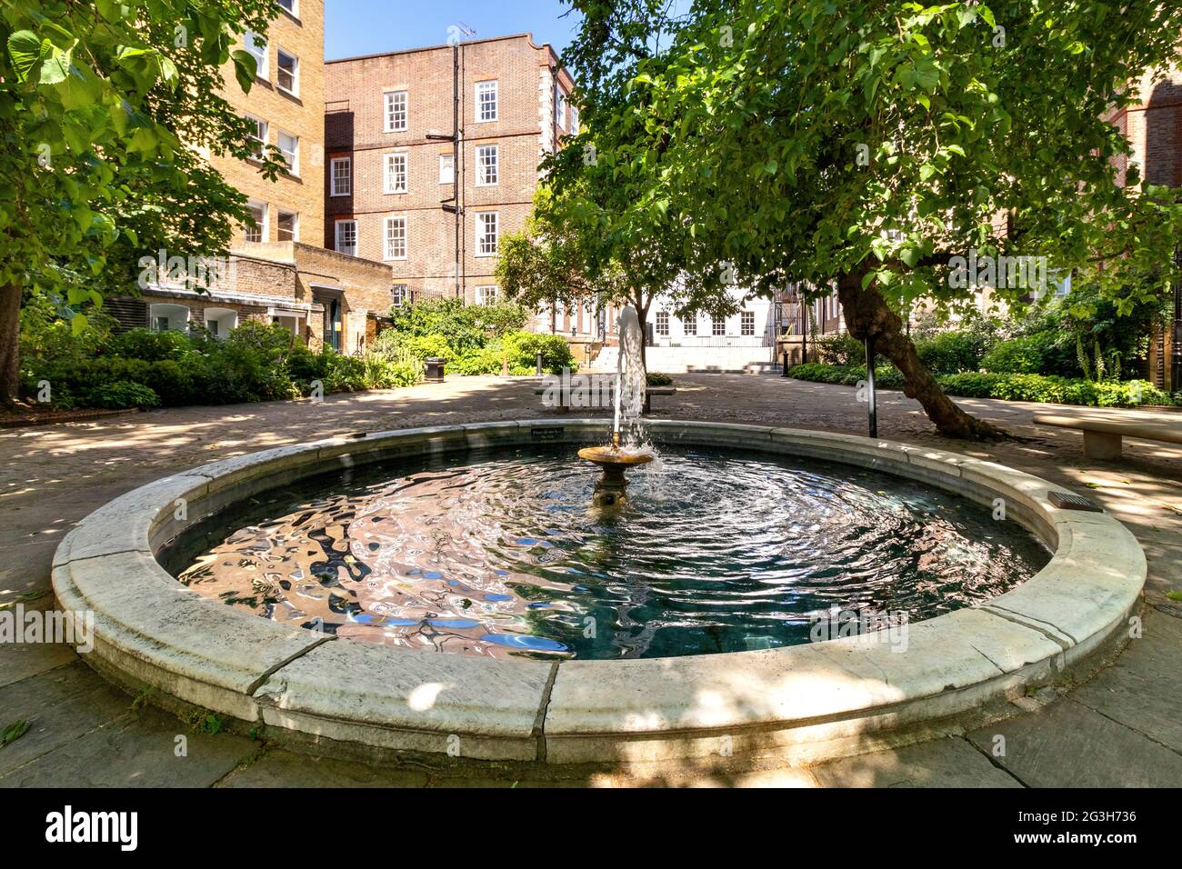 LONDON ENGLAND MITTELTEMPEL EIN MAULBEERBAUM BESCHATTETE HOF MIT BRUNNEN UND TEICH IM FRÜHSOMMER Stockfoto