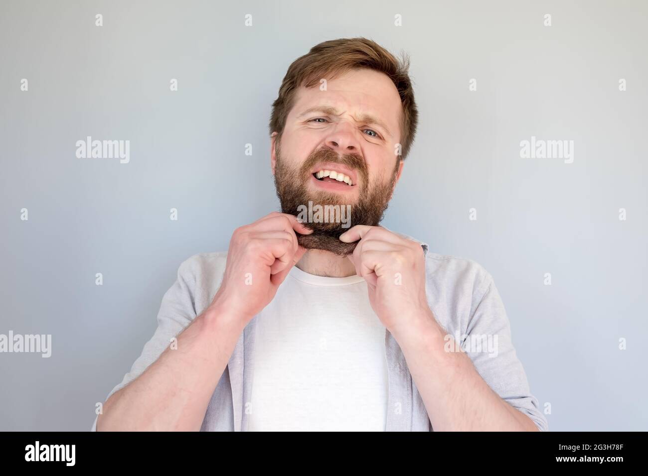 Mann hält Doppelkinn in den Händen, er ist sehr aufgeregt über Übergewicht und Übergewicht. Konzept der richtigen Ernährung und Lebensstil. Stockfoto