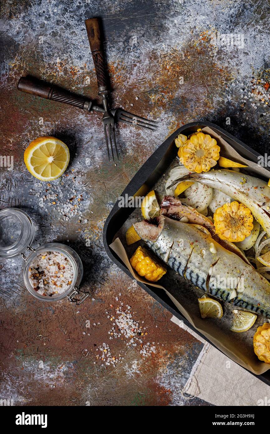 Marinierte Makrele mit Gemüse. Salzwasserfisch mit Gewürzen und Gemüse in einer gusseisernen Backform auf rustikalem Hintergrund gesund und lecker seaf Stockfoto