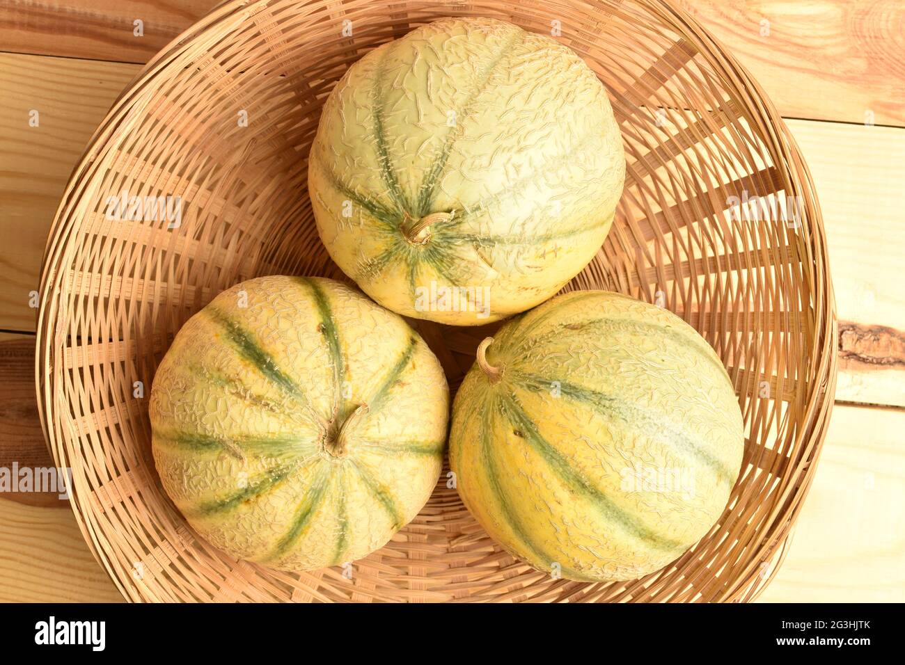 Drei reife Bio-Melone in einer Weidenschale, Nahaufnahme, Draufsicht. Stockfoto