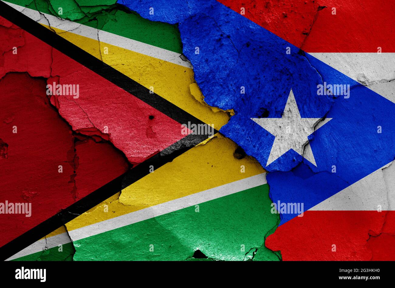 Flaggen von Guyana und Puerto Rico auf rissige Wand gemalt Stockfoto