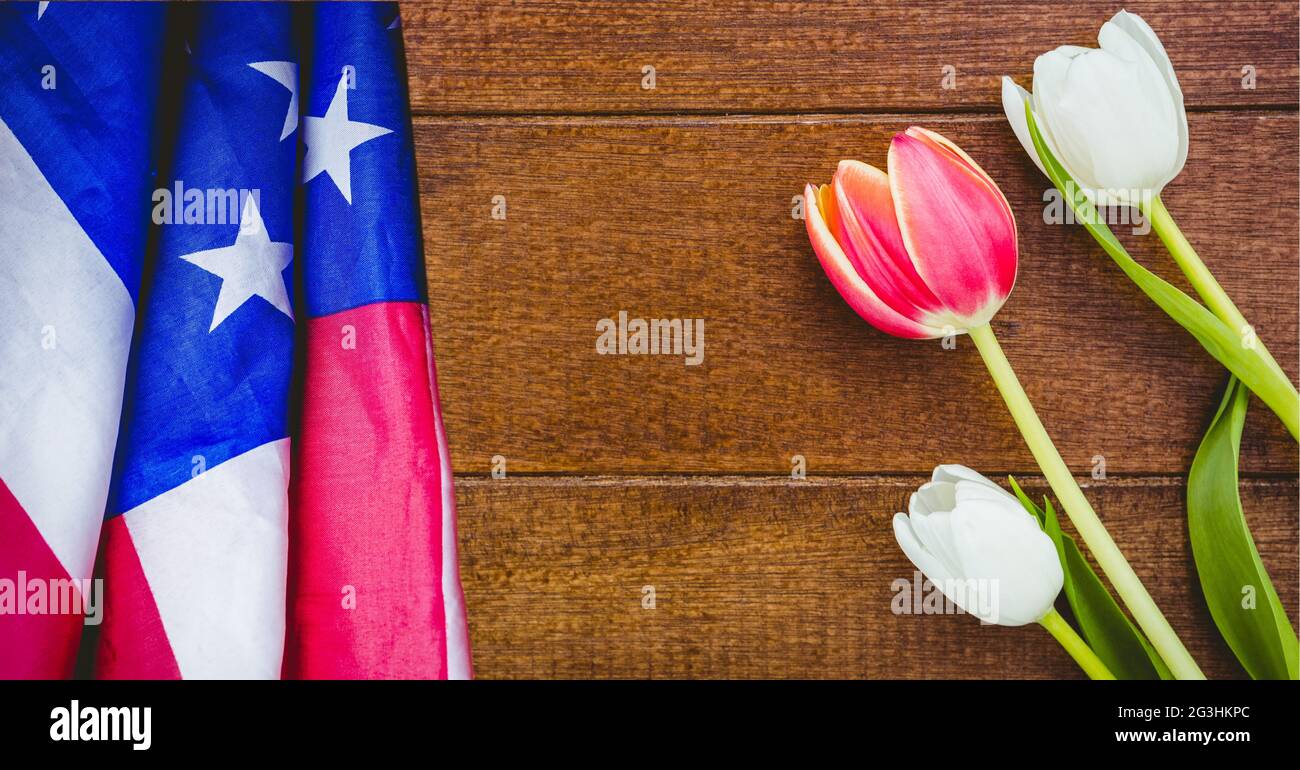 Amerikanische Flagge und rosa und weiße Tulpenblumen auf Holzgrund Stockfoto