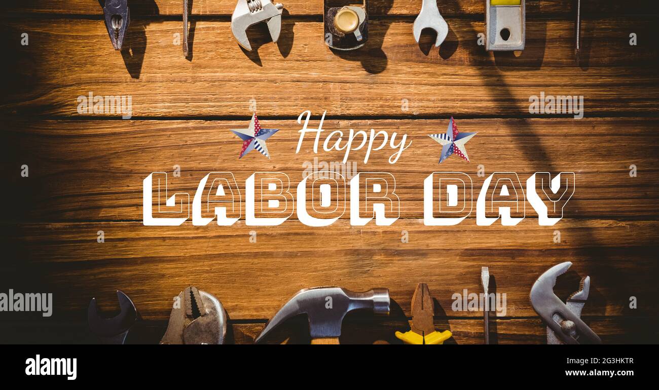 Happy Labor Day Text und Sterne gegen mehrere Werkzeuge auf Holzhintergrund Stockfoto