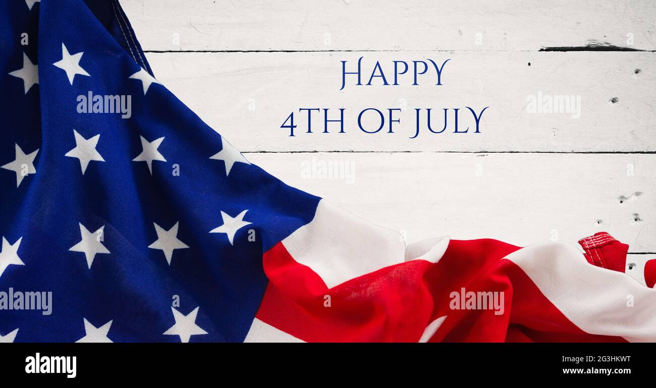 Happy Independence Day Text und wehende amerikanische Flagge vor Holzgrund Stockfoto