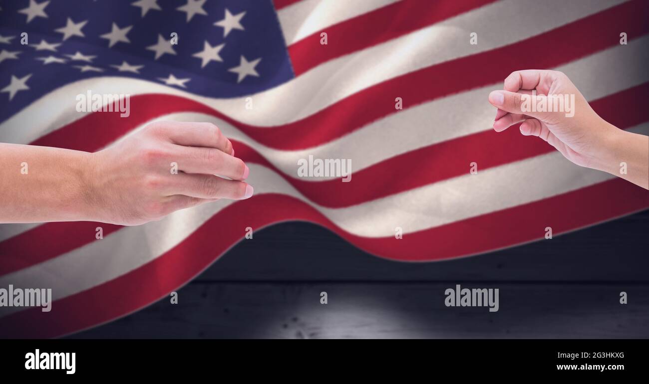 Zusammensetzung aus zwei Händen, die über die wehende amerikanische Flagge über Holztafeln reichen Stockfoto