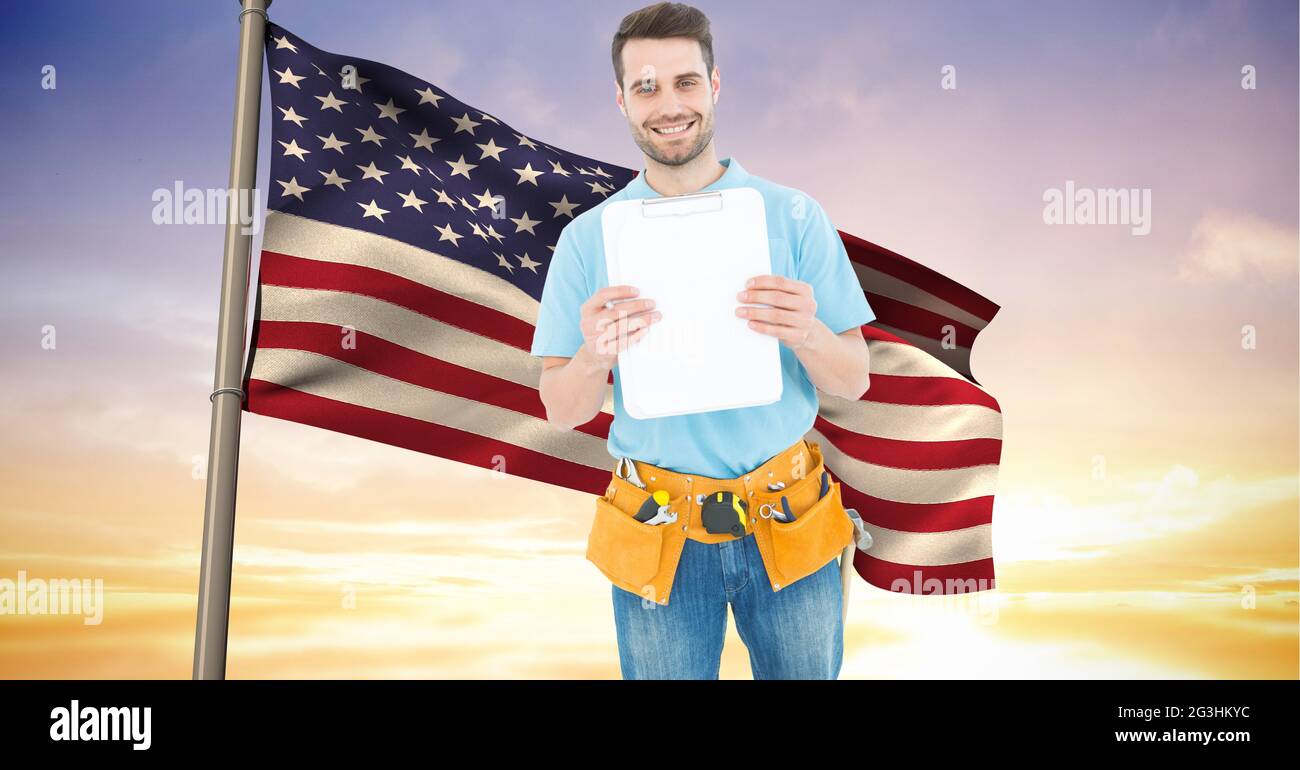 Zusammensetzung eines lächelnden männlichen Bauarbeiters über der wehenden amerikanischen Flagge und dem Sonnenuntergangshimmel Stockfoto