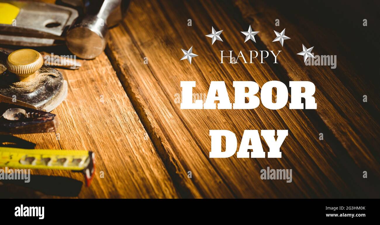 Happy Labor Day Text und Sterne gegen mehrere Werkzeuge auf Holzhintergrund Stockfoto