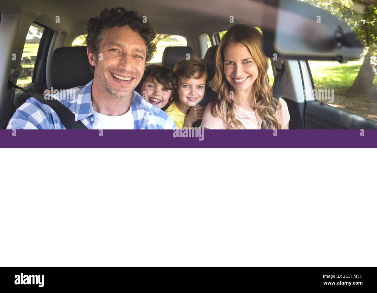Zusammensetzung aus lächelnden Eltern und zwei Kindern, die an sonnigen Tagen im Auto sitzen Stockfoto