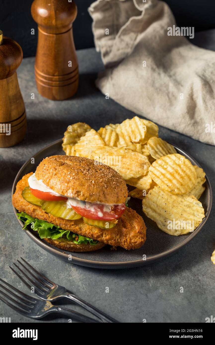 Hausgemachtes knuspriges Fischfilet-Sandwich mit Chips Stockfoto