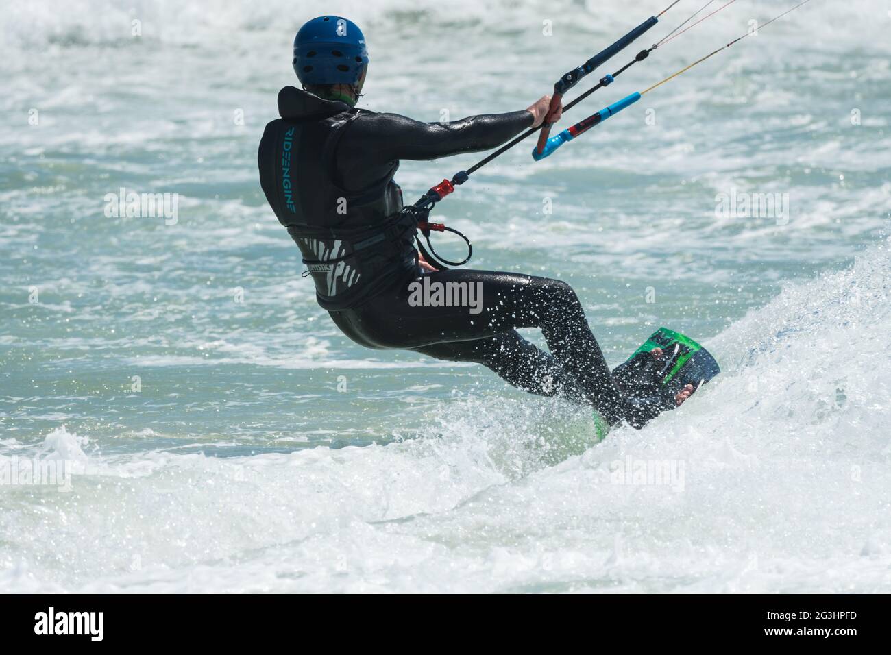 Kitesurfer oder Kite-Boarder, nach hinten gerichtet, hält sich während des Red Bull King of the Air Wettbewerbs in Kapstadt an einer Steuerstange fest Stockfoto