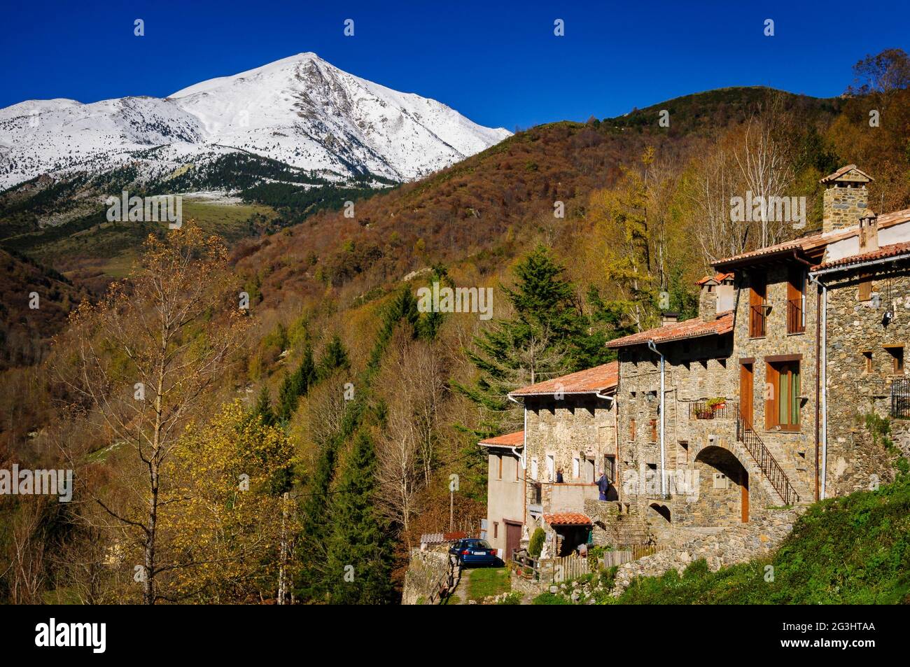 Espinavell Dorf mit dem schneebedeckten Gipfel von Costabona im Hintergrund. (Ripollès, Katalonien, Spanien, Pyrenäen) ESP: Pueblo de Espinavell y el Costabona Stockfoto