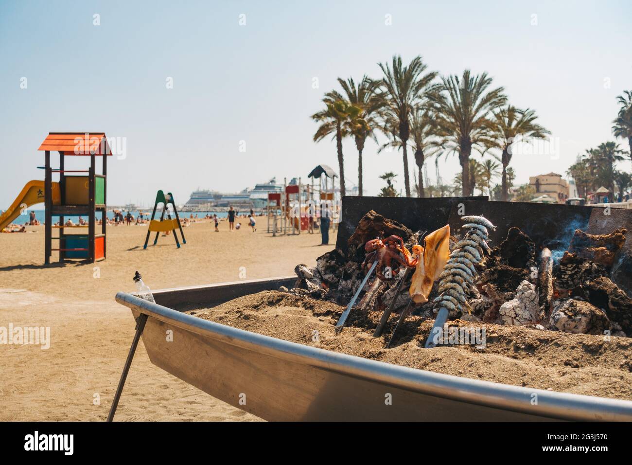 In einem Restaurant am Strand von Malagueta, Málaga, Spanien, werden bei einem behelfsmäßigen Holzfeuer-Barbecue verschiedene Meeresfrüchte gekocht Stockfoto