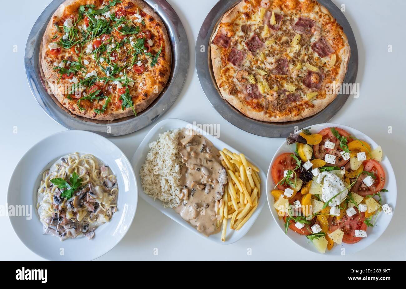 Vielfalt an verschiedenen kulturellen Gerichten in der Tabelle der indischen Lebensmittelteller Pizza, Salat, Reis, Fleisch, Gemüse. Das Panorama des Essens. Draufsicht Stockfoto