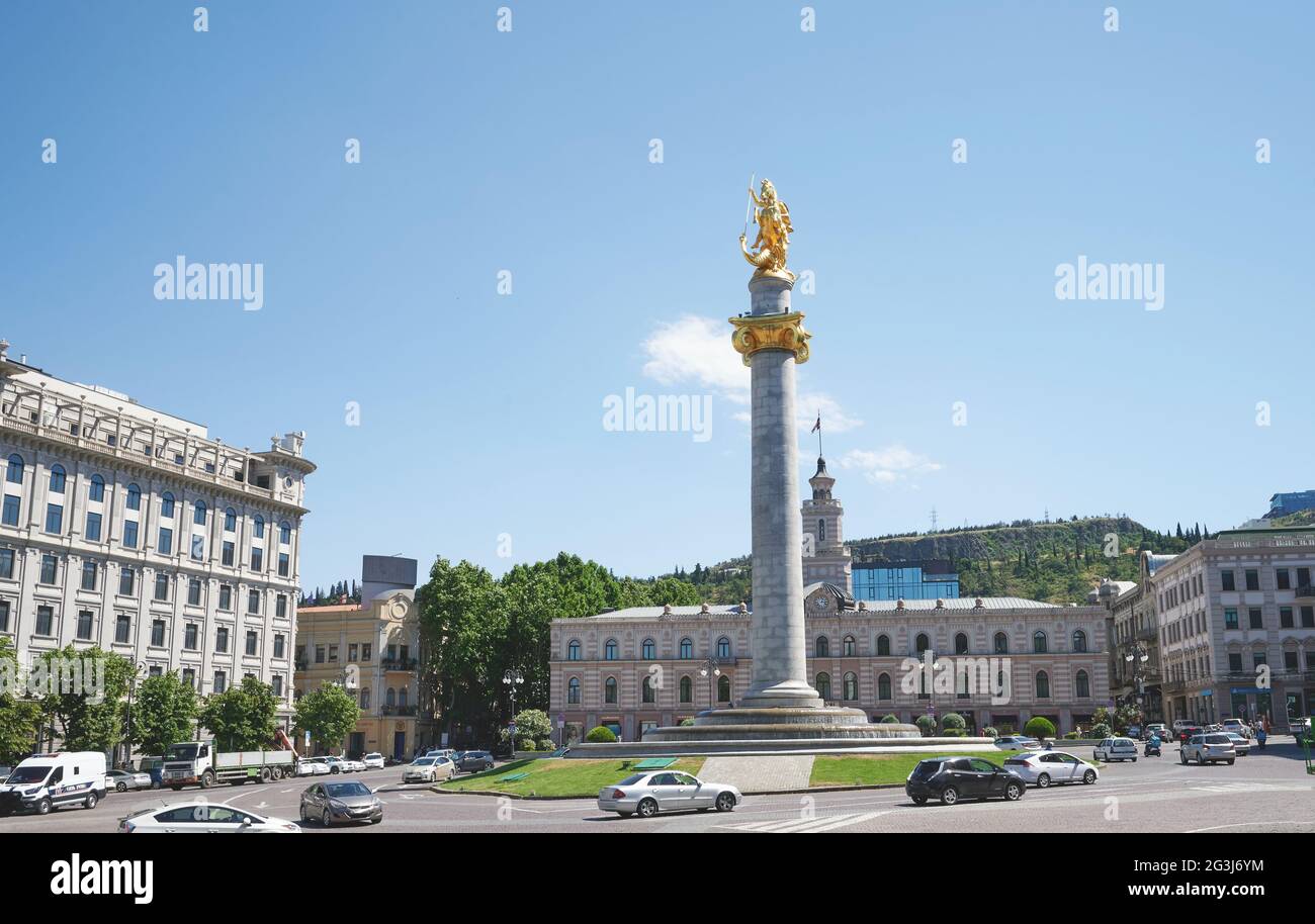 Platz in Tiflis mit Denkmal auf hellblauem Himmel Hintergrund Stockfoto