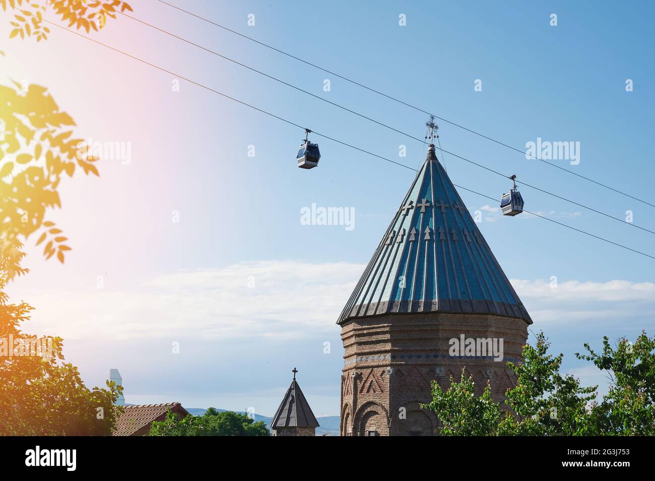 Dach der Kirche in Tiflis auf blauem Himmel Hintergrund mit Seilbahn Stockfoto