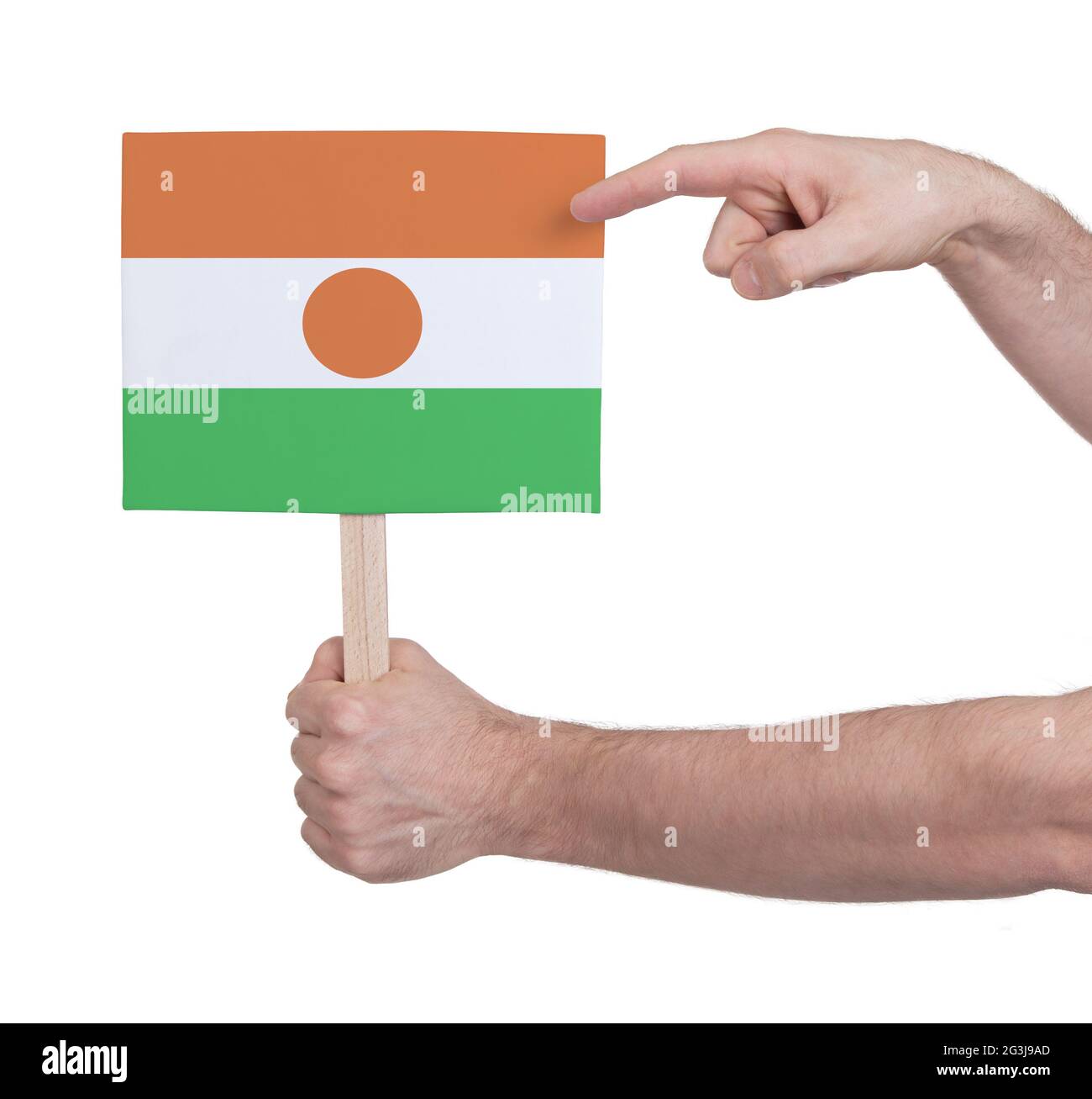 Hand hält kleine Karte - Flagge von Niger Stockfoto