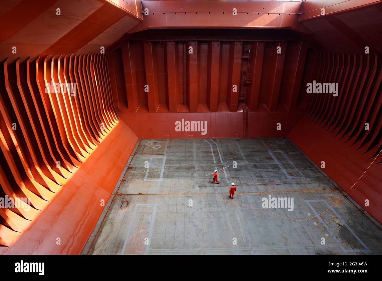Crew bereitet Frachtraum vor dem Verladen von Zement vor, wendet einen Laderaum im Laderaum eines großen Frachtschiffes an Stockfoto