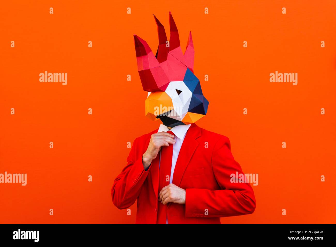 Cooler Mann trägt 3d Origami Maske mit stilvollen farbigen Kleidung - Kreatives Konzept für die Werbung, Tier Kopf Maske dabei lustige Dinge auf bunten Rücken Stockfoto