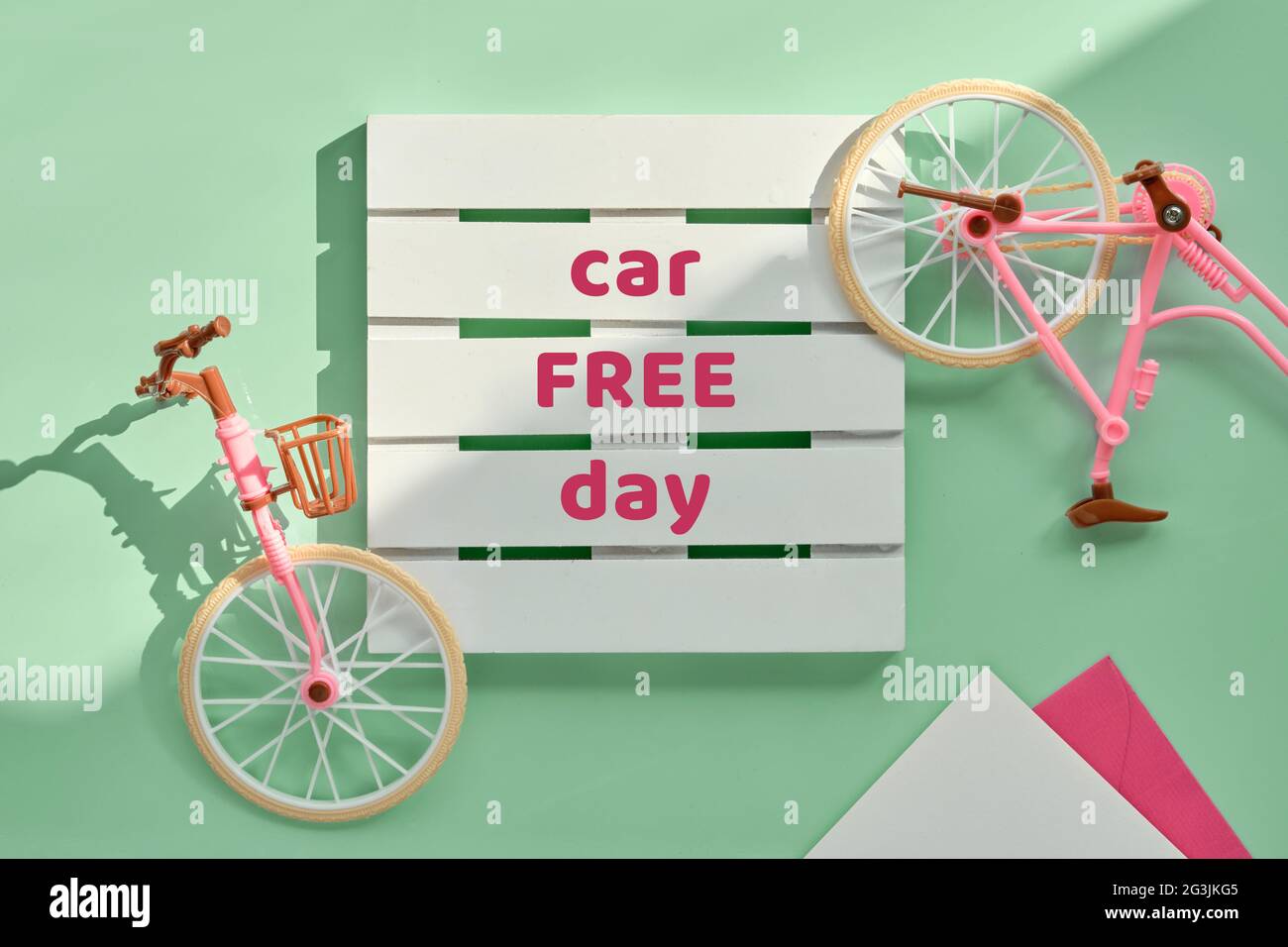 Autofreier Tag September 22. Spielzeug Modell Stadt Fahrrad mit Schatten auf mintgrün Hintergrund. Flaches Lay-Design, Draufsicht, minimalistisches Retro-Vintage-Design. Stockfoto