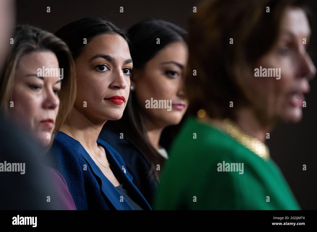 Die Vertreterin Alexandria Ocasio-Cortez (D-NY) hört der Sprecherin des Repräsentantenhauses Nancy Pelosi (D-CA) während einer Pressekonferenz zu, auf der am Mittwoch, dem 16. Juni, im US-Kapitol in Washington, DC, die Mitglieder des neu gegründeten Select Committee on Economic Disparity and Fairness in Growth 2021. Während Präsident Biden heute zum ersten Mal mit dem russischen Präsidenten Wladimir Putin zusammentrat, werden die Infrastrukturverhandlungen im Kapitol fortgesetzt, obwohl die Demokraten den Prozess der Aussöhnung des Haushalts vorantreiben, der nur 50 Stimmen erfordert. (Graeme Sloan/Sipa USA) Stockfoto