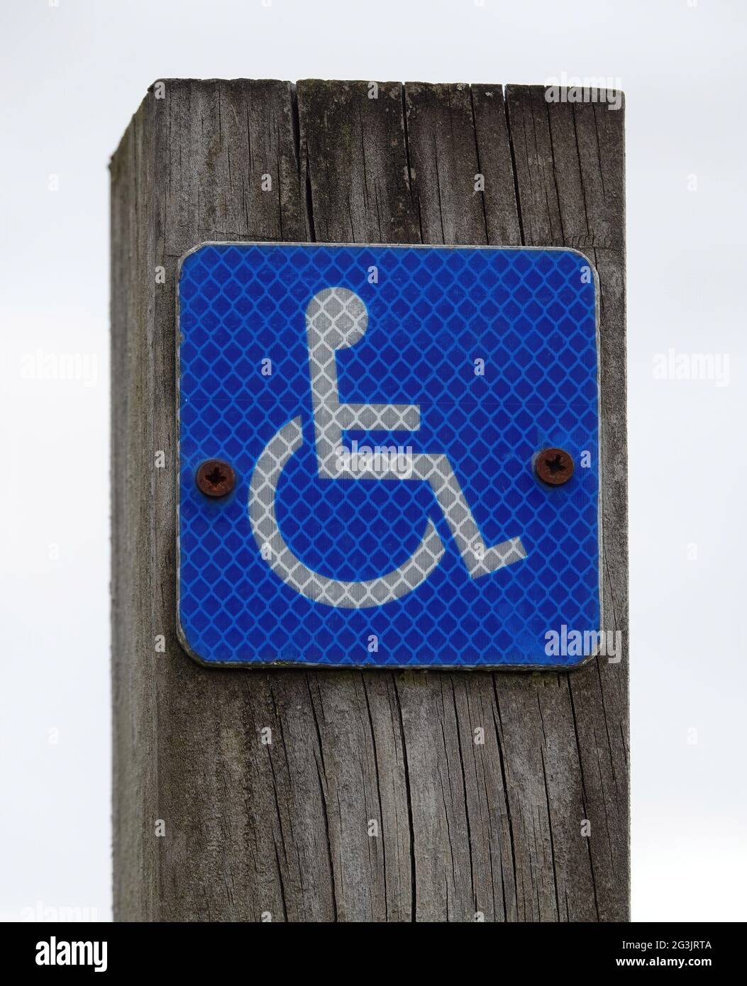 Nahaufnahme eines behindertengerechten Schildes, das an der Holzdiele angebracht ist Stockfoto