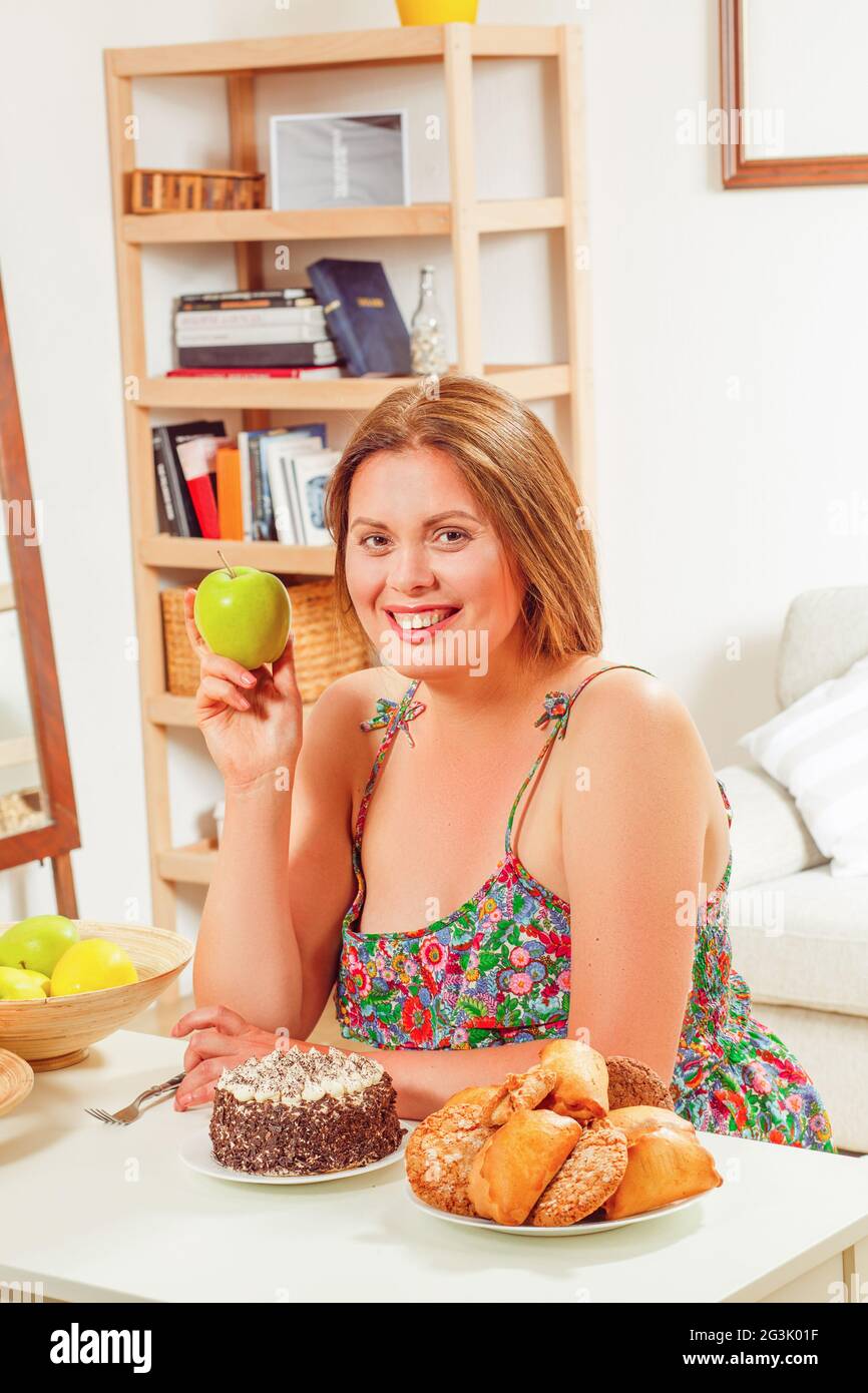 Fette Frau am Tisch nach Hause Stockfoto