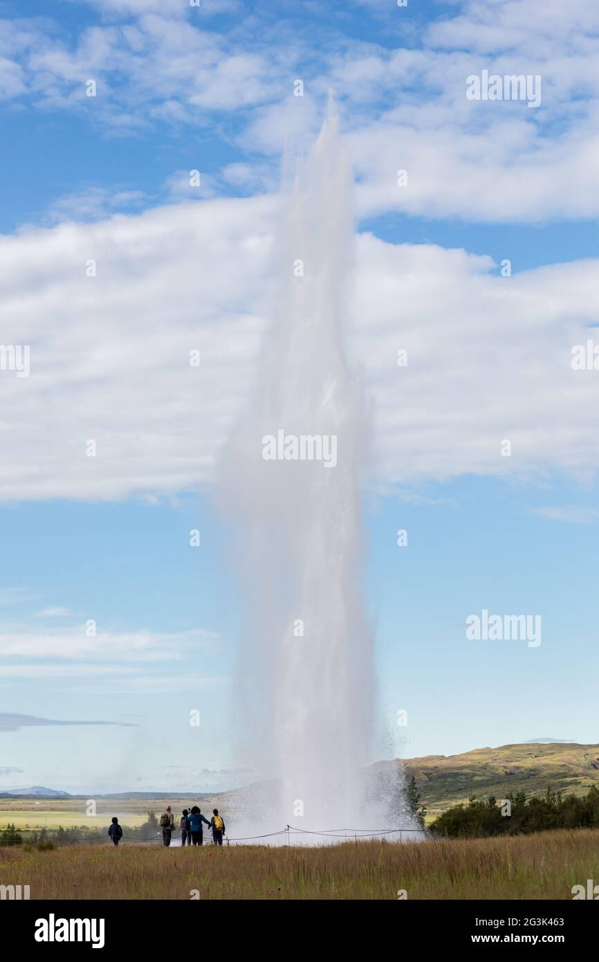 Beeindruckende Eruption des größten aktiven Geysir, Strokkur, mit Touristen warten herum, Golden Circle Stockfoto