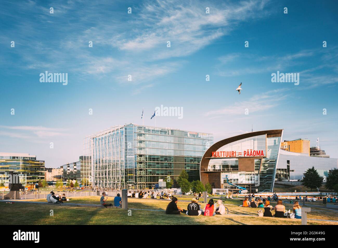 Am sonnigen Sommerabend entspannen sich die Menschen vor dem Kiasma-Museum und dem Sanoma-Gebäude in Helsinki, Finnland Stockfoto