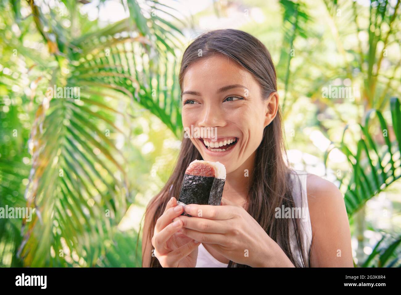 Spam musubi Reis Ball Sandwich Asiatische Frau Tourist essen japanische Snack Essen typisch für hawaii-Markt in Hawaii. Stockfoto