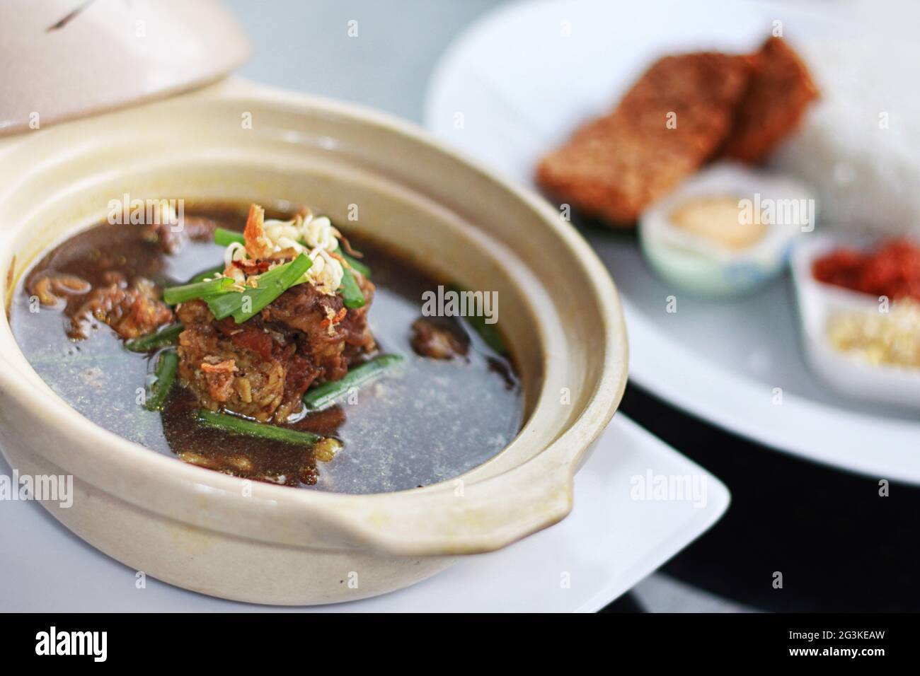 Rawon ist eine traditionelle javanesische schwarze Fleischsuppe mit stark schmeckenden traditionellen indonesischen Gewürzen, serviert mit Sprossen und gesalzenem Ei Stockfoto