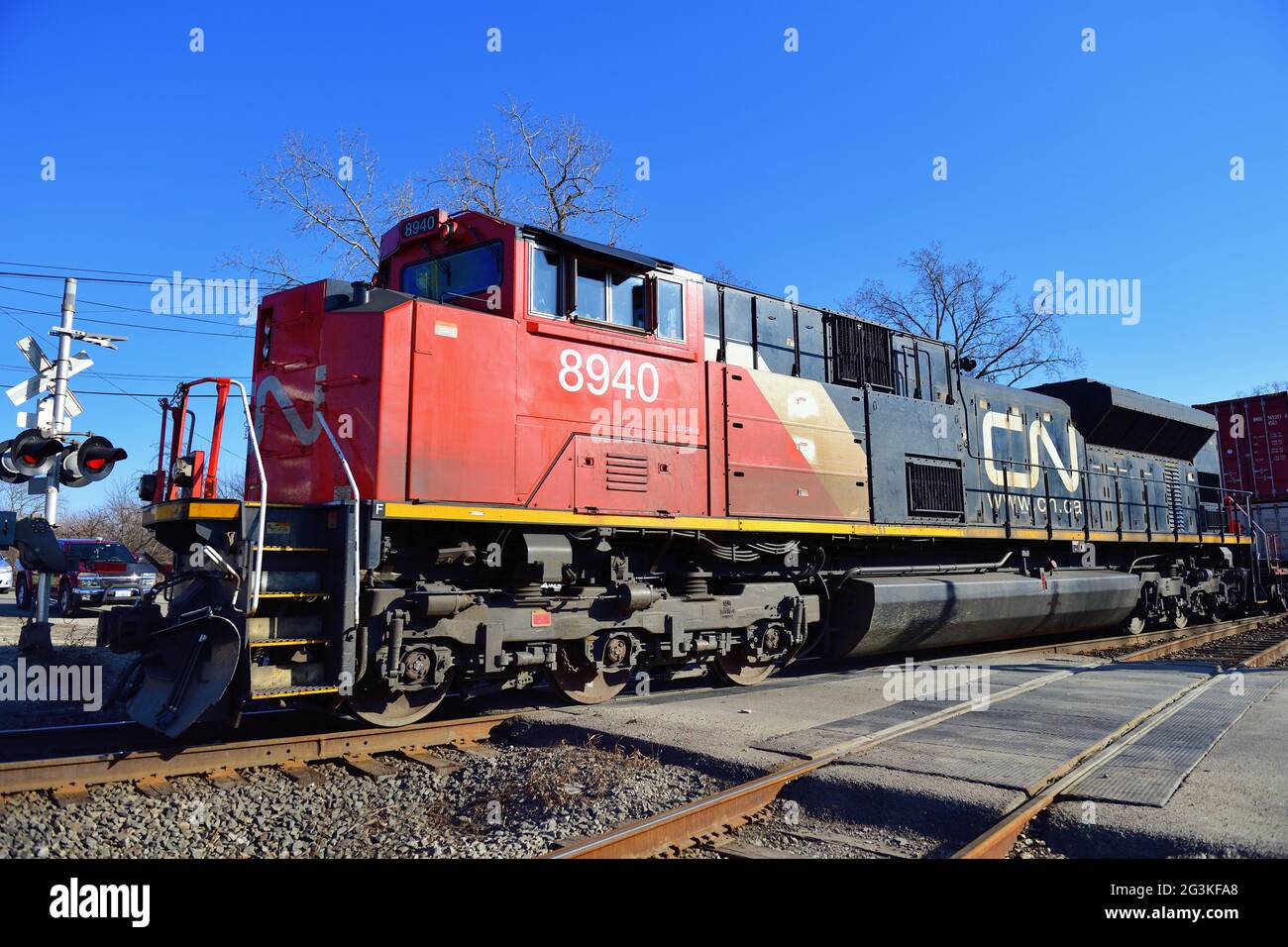 Elgin, Illinois, USA. Eine Lokomotive der Canadian National Railway führt einen intermodalen Güterzug durch einen Bahnübergang nach Norden. Stockfoto